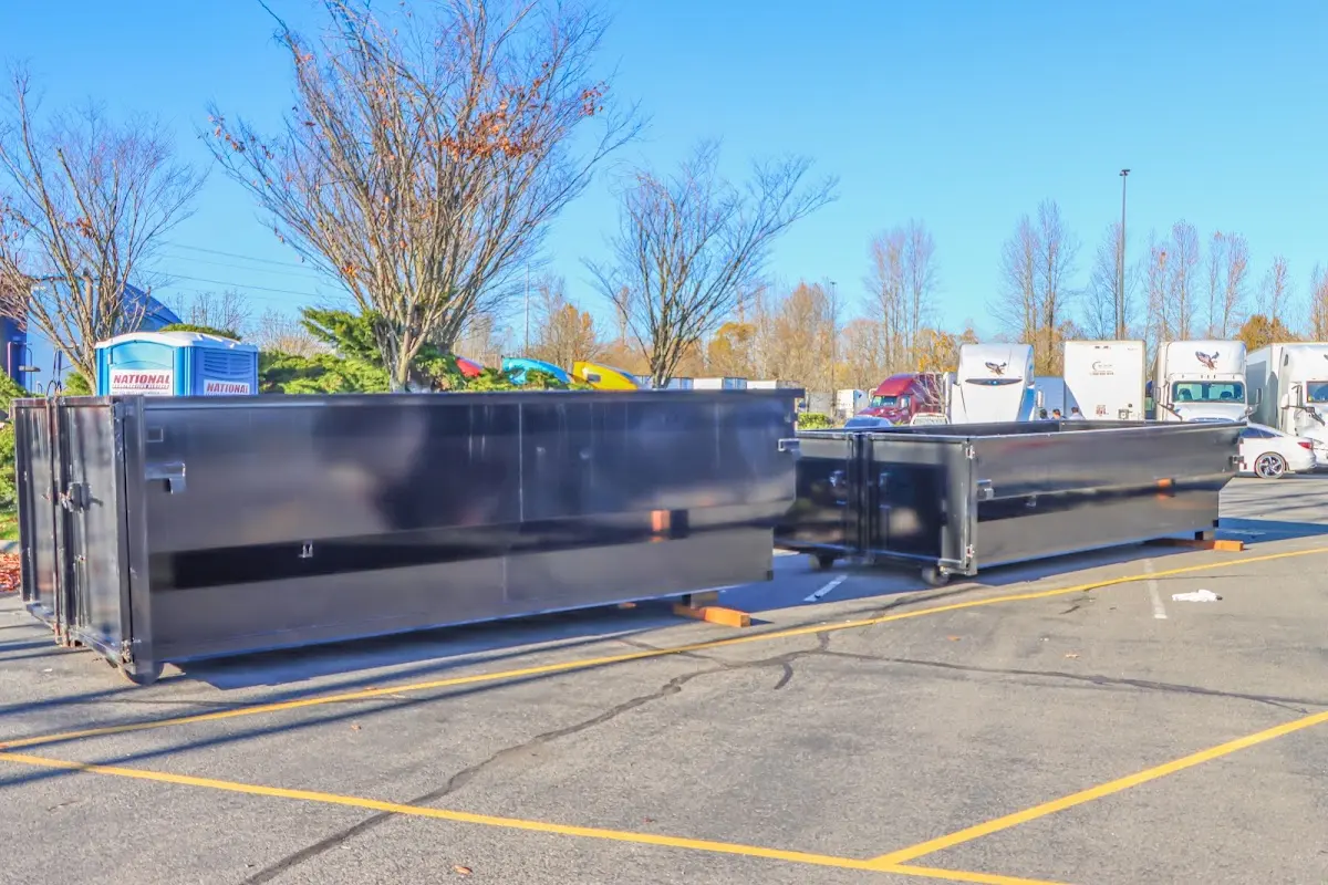 Professional dumpster rental service with roll-off container on residential driveway in Calhoun